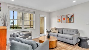 A modern living room with a grey sofa, a round coffee table, and a side table.
