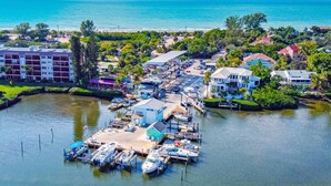 An aerial view of a marina with boats docked, surrounded by residential buildings and greenery. - 1200 Tree Bay  (Siesta Key)