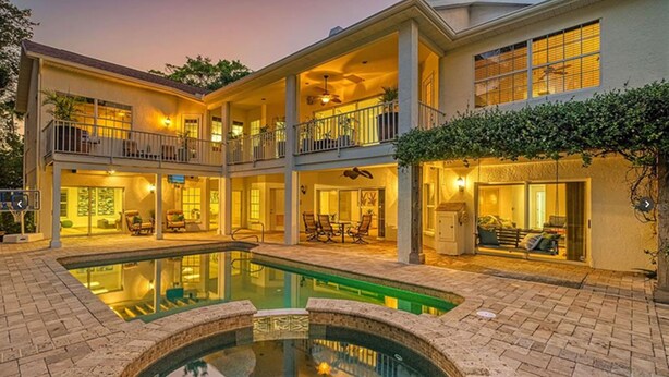 A multi-story hotel with a swimming pool, outdoor seating, and a well-lit entrance. - 1200 Tree Bay  (Siesta Key)
