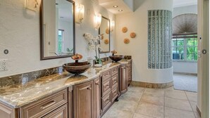 A bathroom with a large mirror, a bowl sink, and a vanity with drawers. - 1200 Tree Bay  (Siesta Key)