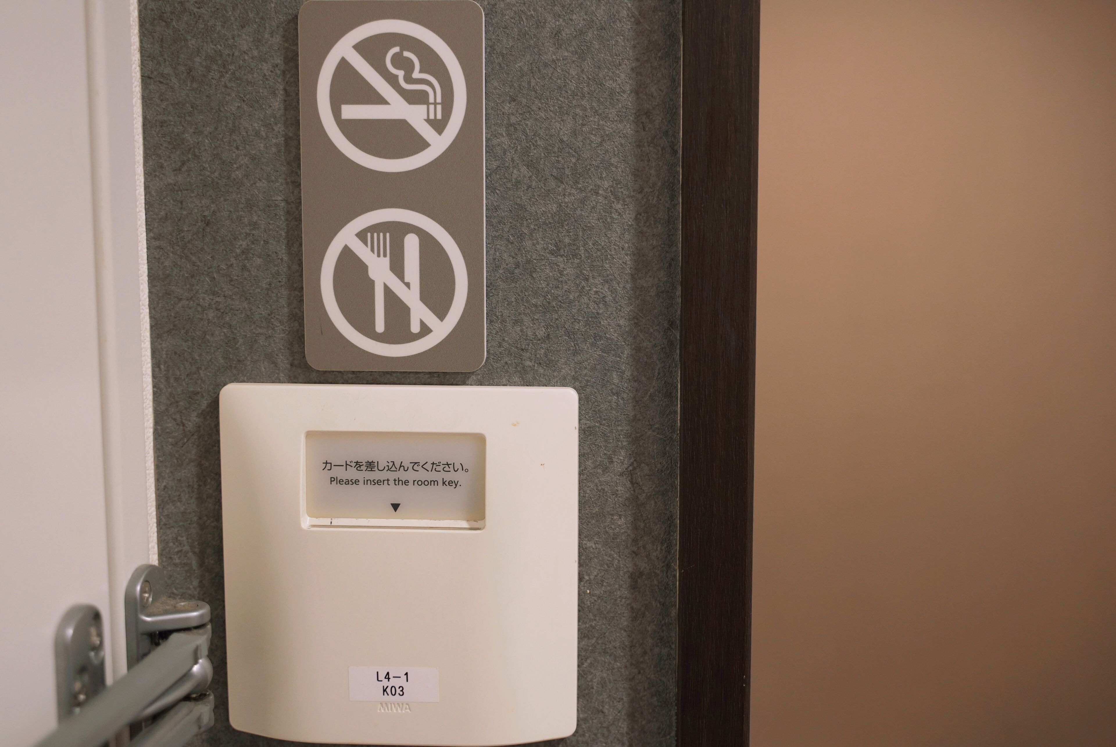 A room key card slot with a no-smoking and no-eating sign above it.