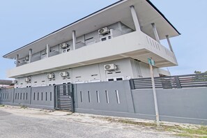 A modern building with multiple air conditioning units, a gated entrance, and a flat roof. - Hotel O Lavina Guesthouse (Dumai)