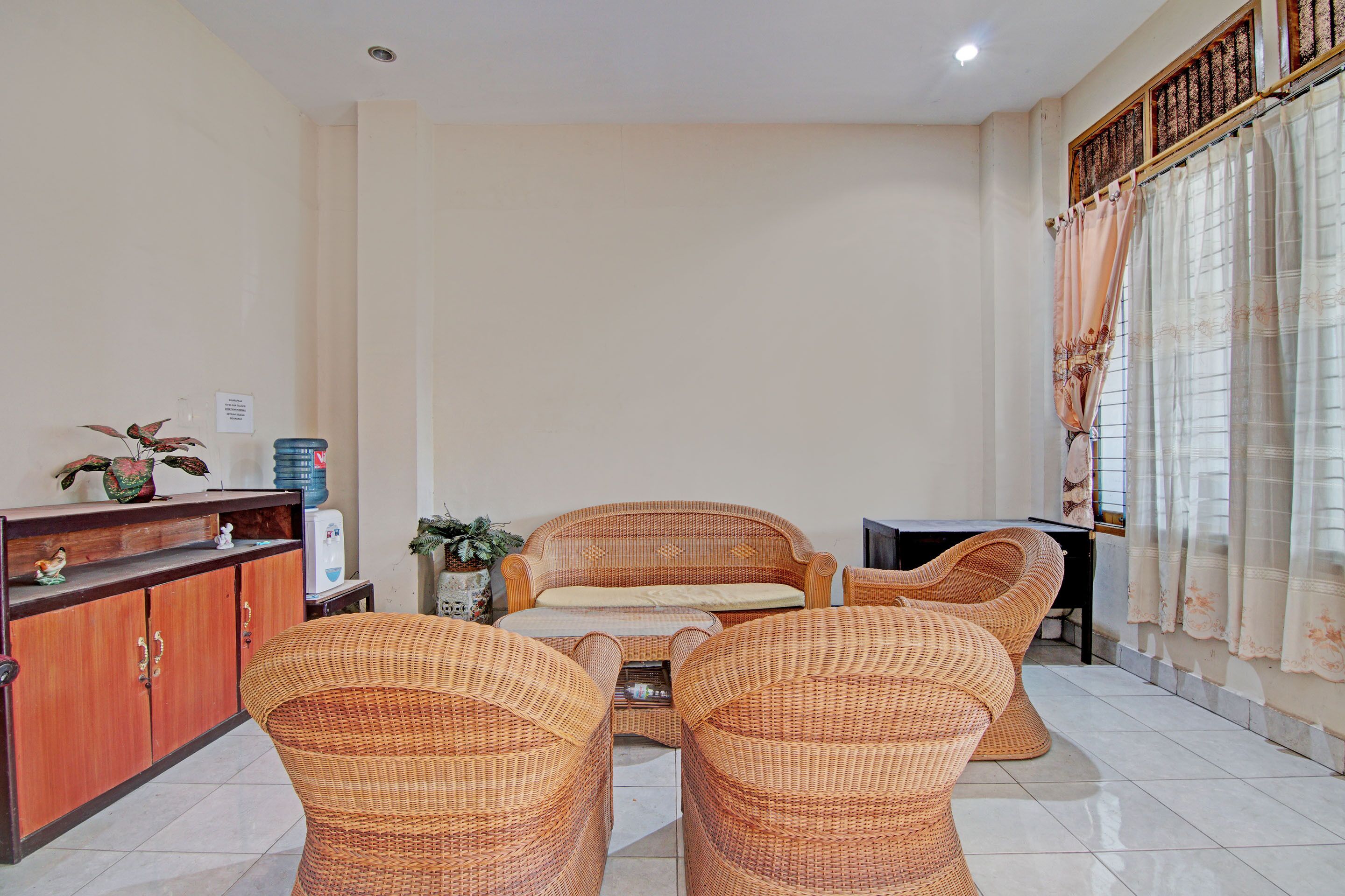 A living room with a sofa, two armchairs, a coffee table, and a wooden cabinet.