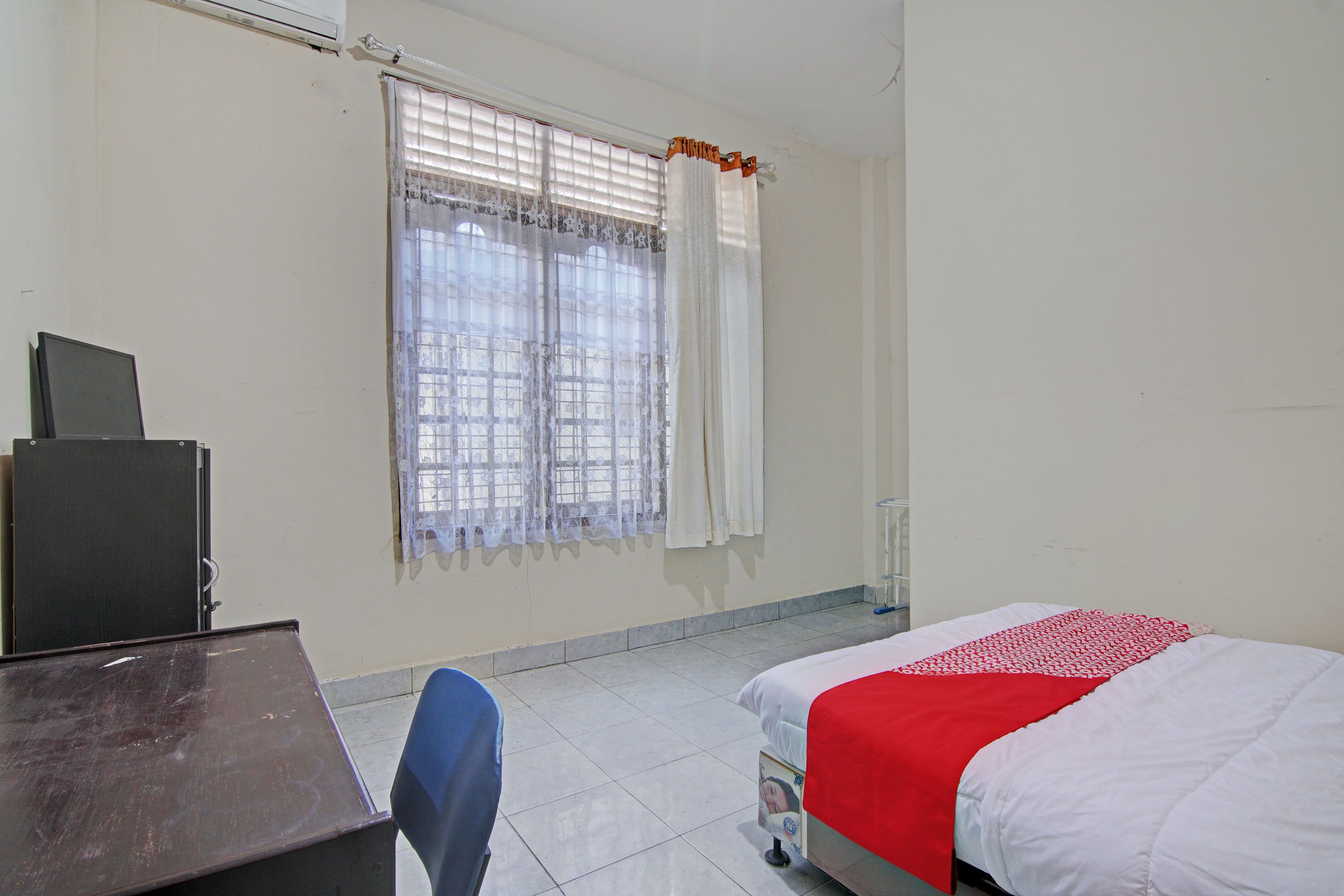 A room with a bed, a desk, and a chair.