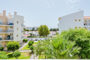 A residential area with multi-story buildings, a central tree, and a parking area.
