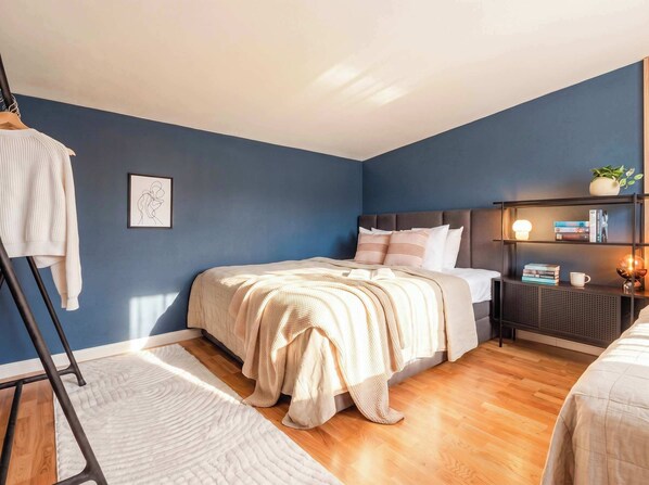 A bedroom with a bed, bedside tables, a nightstand, a lamp, and a framed picture on the wall. - TurnKey | Two level Charles Square Apartment I (Praha 2)
