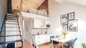 A modern apartment with a staircase, a kitchen, and a dining area. - TurnKey | Two level Charles Square Apartment I (Praha 2)