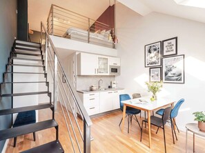 Ein modernes Apartment mit Treppe, einer Küche und einem Essbereich.