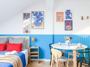 Un dormitorio moderno con una cama, mesita de noche y una pared decorada con arte abstracto.