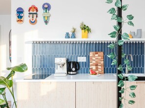 A kitchen with a coffee maker, a fruit bowl, and decorative items on the counter.