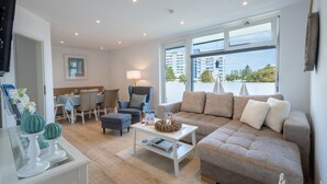 Un salon moderne avec un canapé, une table basse et un coin repas.