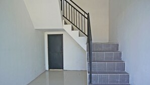 A staircase with black railings leading to a door. - Hotel O Kost Putih Syariah (Blitar)