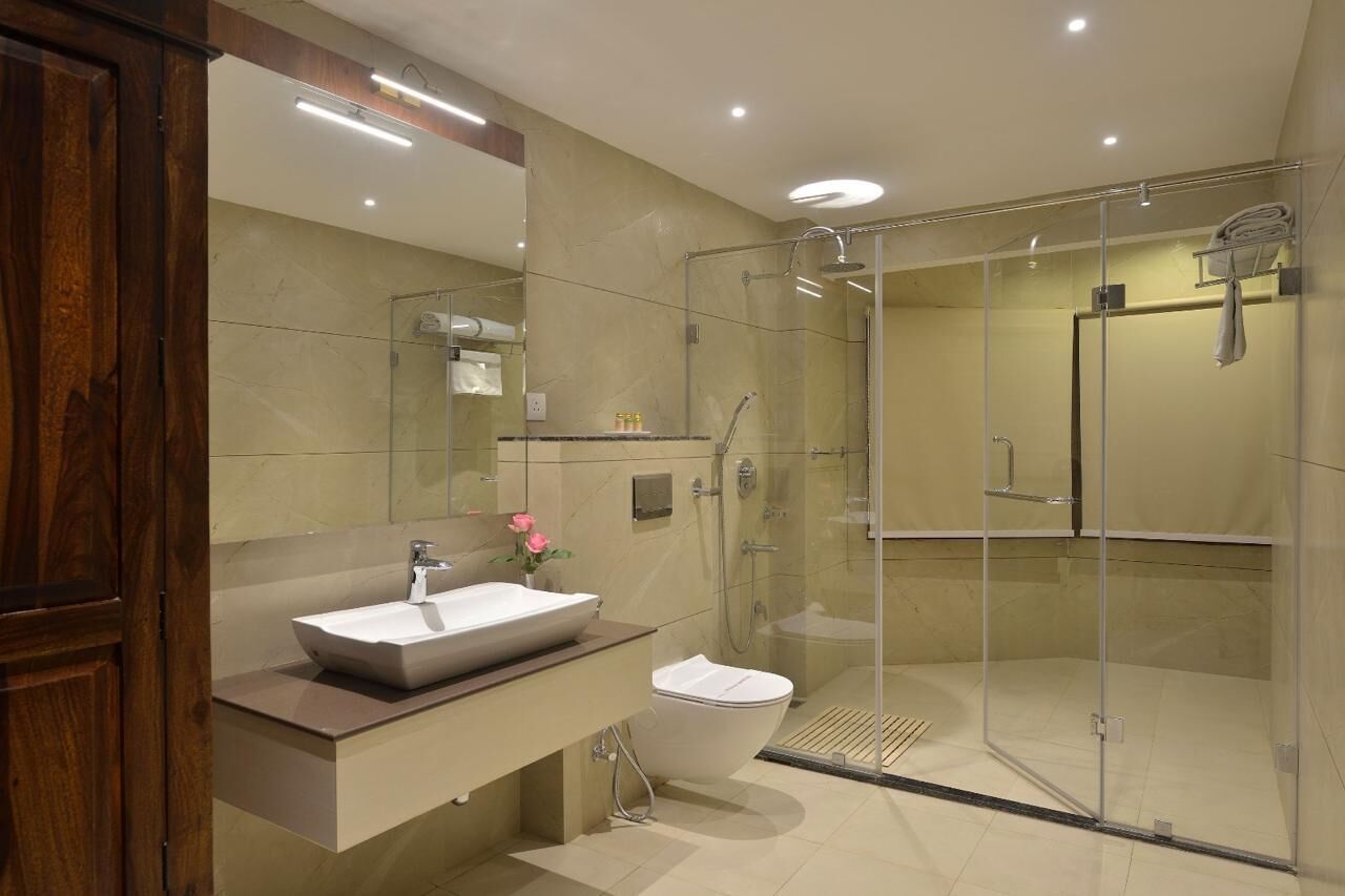 A modern bathroom with a glass-enclosed shower, a large mirror, and a wooden vanity.