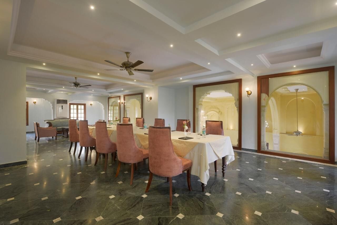 Un espace repas avec une longue table, plusieurs chaises et un ventilateur de plafond.