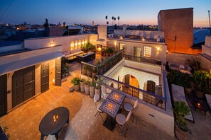 A rooftop terrace with outdoor seating, a fire pit, and potted plants. - Riad Star by Marrakech Riad (Marrakech)
