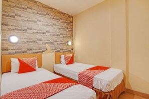 A hotel room with two beds, each with white bedding and red accents, a wooden headboard, and a wall with text in multiple languages. - Hotel O Kalista Guest House Syariah (Pekanbaru)