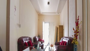 A living room with two red leather sofas, a coffee table, and a ceiling fan.