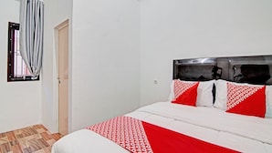 A bedroom with a bed, a window with curtains, and a door. - OYO 92946 Dekna Homestay Syariah (Pekanbaru)