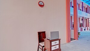 A wooden desk with a laptop, a chair, and a clock on the wall. - OYO 92946 Dekna Homestay Syariah (Pekanbaru)
