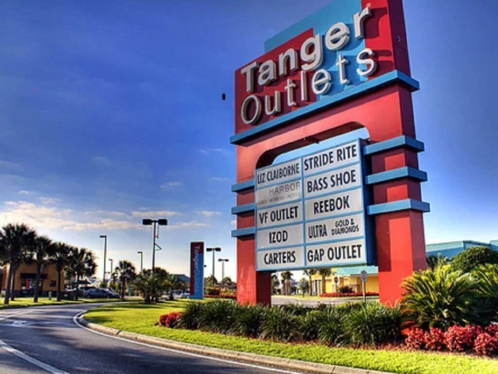 A Tanger Outlets sign with various brand names listed.