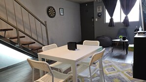 A dining area with a white table and chairs, a dartboard, and a staircase. - Agua Azul by tuhost (Guadalupe)