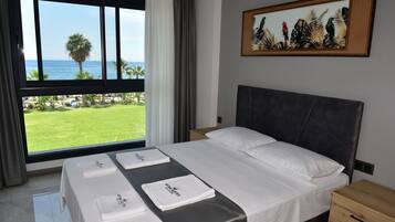 A hotel room with a large window, a bed with white linens, a headboard, a nightstand, and a painting on the wall.