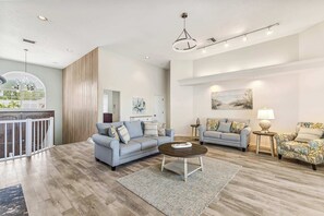 A spacious living room with a wooden floor, two sofas, a coffee table, and a painting on the wall. - Luxury 6BR Retreat with Beach Access (Sarasota)