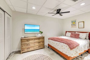 A bedroom with a bed, a dresser, a ceiling fan, and a television. - Luxury 6BR Retreat with Beach Access (Sarasota)