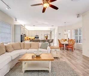A spacious living room with a large sectional sofa, a wooden coffee table, and a dining area with a round table and chairs. - Luxury 6BR Retreat with Beach Access (Sarasota)