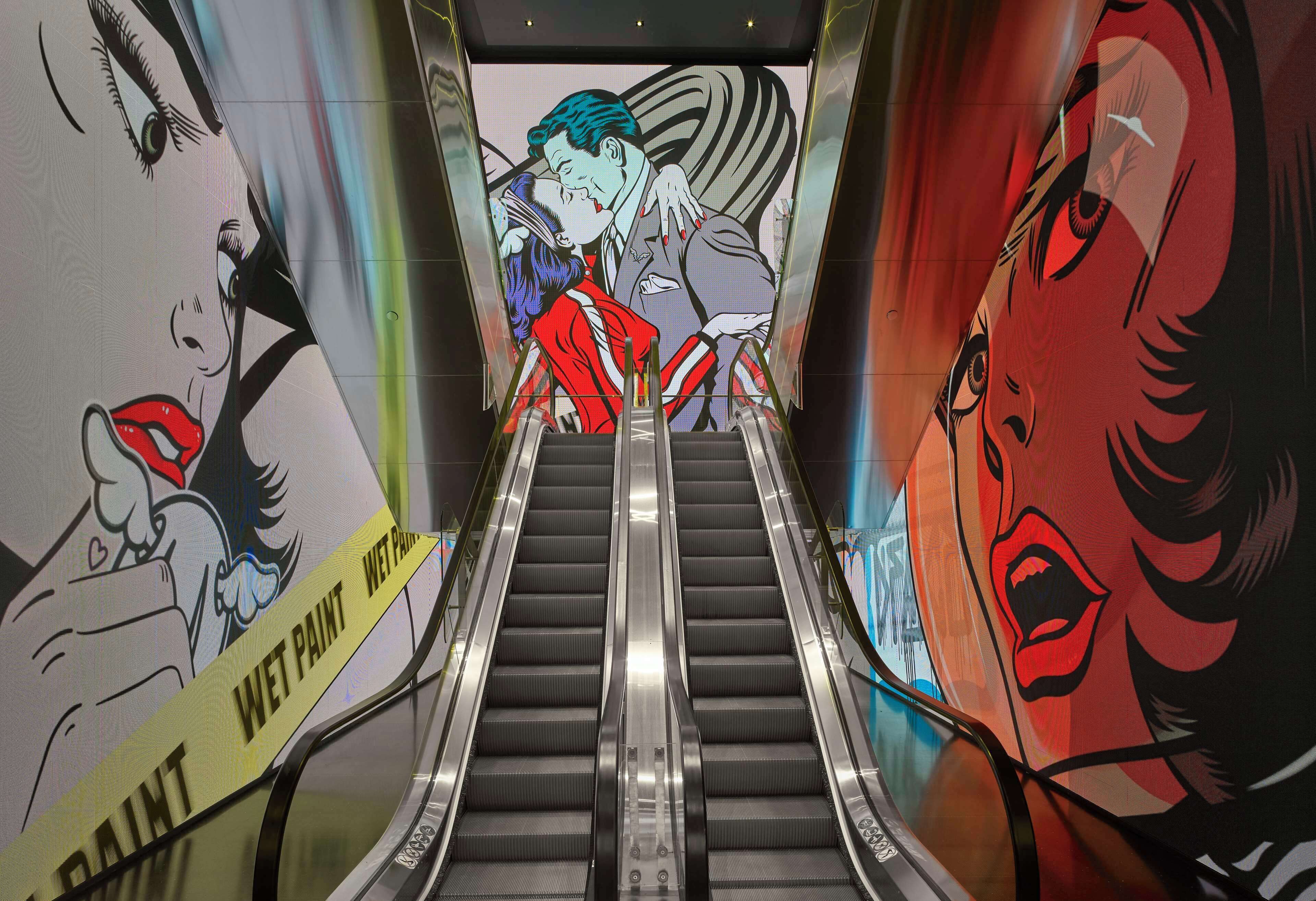 An escalator with a mural on the walls depicting a romantic scene.