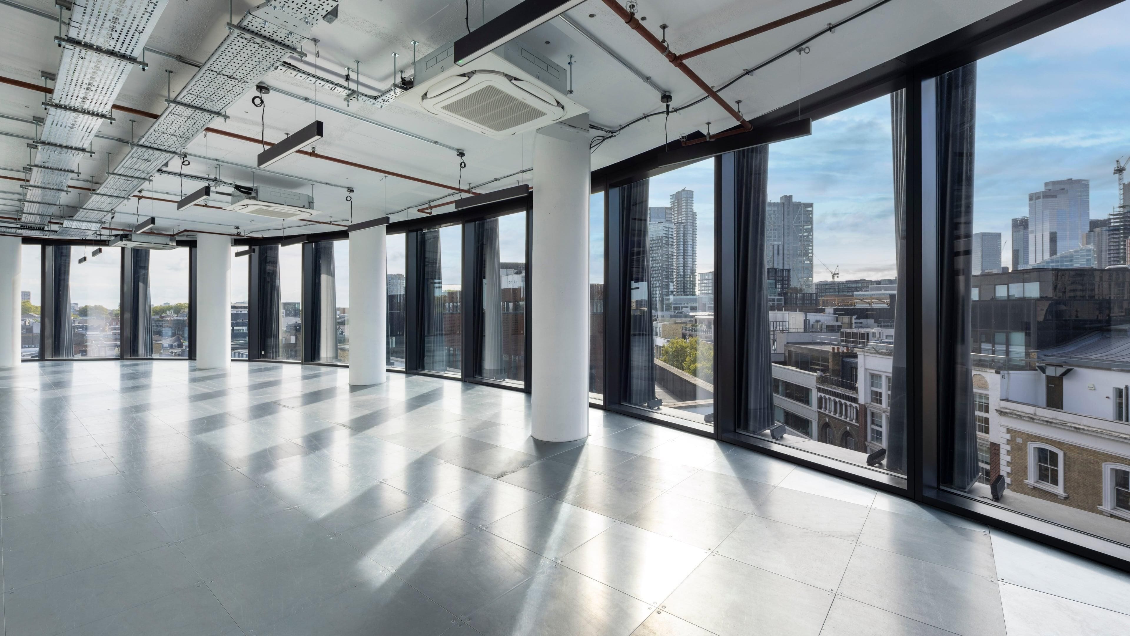 A spacious, modern interior with large windows offering views of a cityscape.