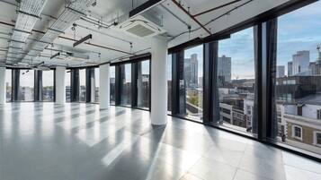 A spacious, modern interior with large windows offering views of a cityscape.