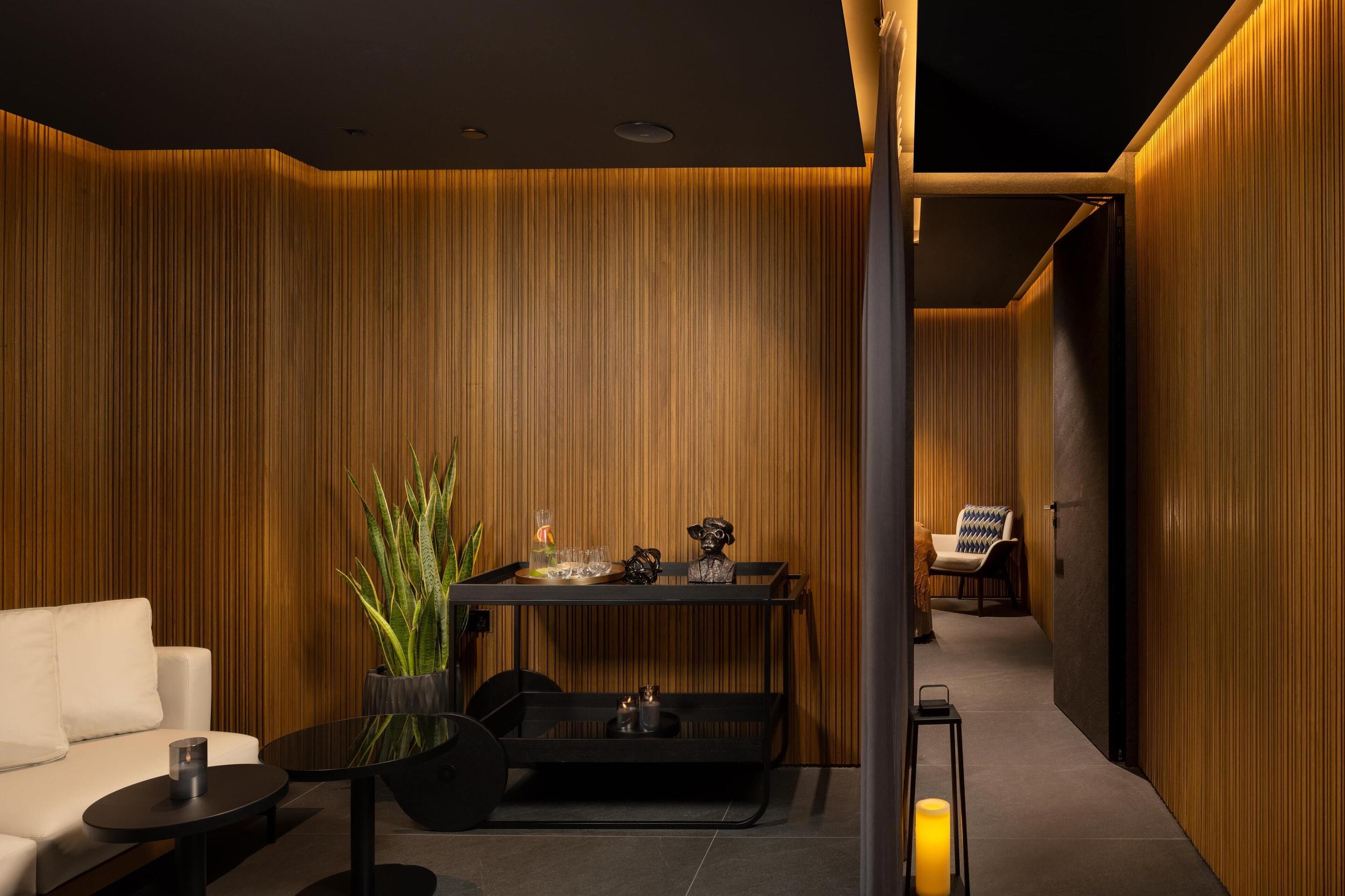 Un intérieur moderne comprenant un canapé, une petite table, une plante décorative et une chaise.