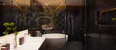 A modern bathroom with a large bathtub, a separate sink, and a glass-enclosed shower area.