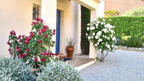 A building with a tiled roof, a blue door, and a gravel driveway. - Villa Rêves de Sorgues (Saumane-de-Vaucluse)