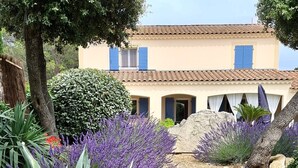 A garden pathway leading to a building with a tiled roof and blue shutters. - Villa Rêves de Sorgues (Saumane-de-Vaucluse)