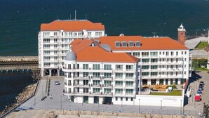 Ein modernes Hotel mit mehreren Etagen, Balkonen und Meerblick.