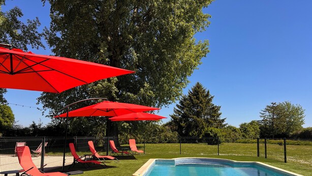 A swimming pool with red umbrellas and lounge chairs. - La Graviere - Detached 28pers villa near Paris (Fontenay-Trésigny)