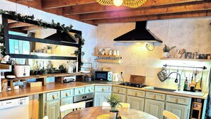 Une cuisine avec des meubles de rangement en bois, une table à manger et des chaises.