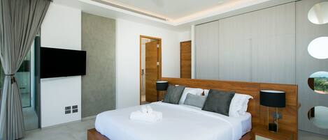 A modern hotel room with a large bed, wooden headboard, and a ceiling fan.