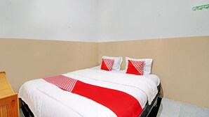 A neatly made bed with a red and white bedspread, two pillows with a red and white pattern, and a wooden nightstand to the left. - Hotel O Marvel House Syariah (Pekanbaru)