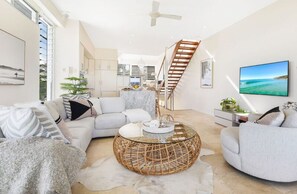 A modern living room with a sofa, armchairs, a coffee table, and a TV. - Soul on Sunshine - Divine Sunshine Beach villa (Sunshine Beach)