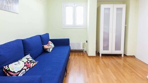 A room with a blue sofa, a radiator, and a wardrobe. - Retire with Outstanding Lycabettus View (Athens)