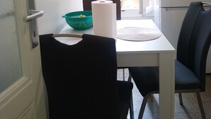 A small, bright room with a white table, a black chair, and a green bowl. - Charming flat center and near the lake  (Genève)