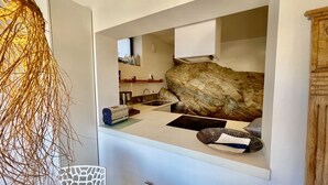 A modern kitchen with a stone backsplash, a built-in stove, and a sink.