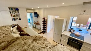 A modern kitchen with a built-in oven, a refrigerator, and a dining area with a table and chairs.