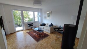 A modern living room with a sofa, two armchairs, a coffee table, and a fireplace.