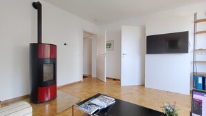 A living room with a fireplace, a television, and a bookshelf.