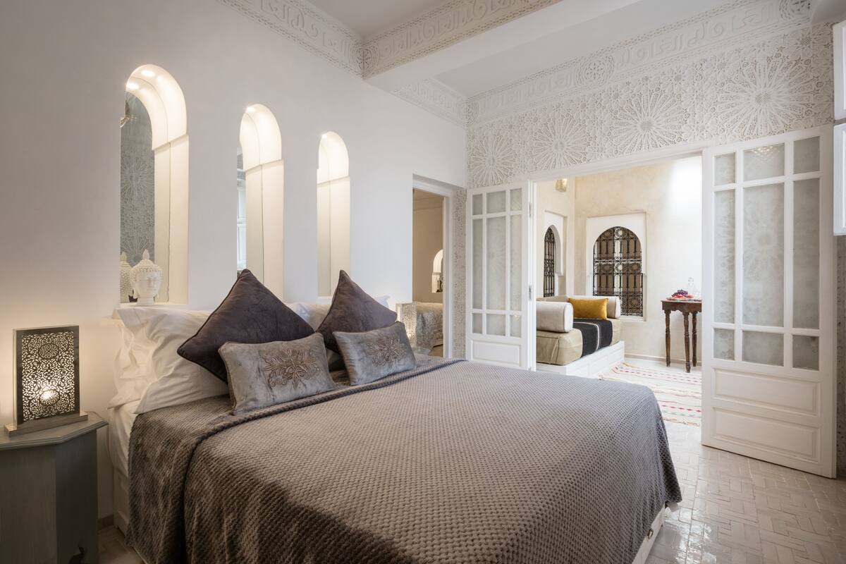Une chambre à coucher avec un grand lit, une table de chevet et un panneau décoratif mural.