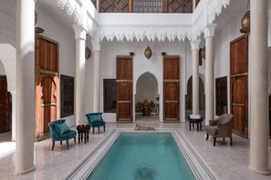 A courtyard with a swimming pool, wooden doors, and seating areas. - Riad Spice by Marrakech Riad (Marrakech)